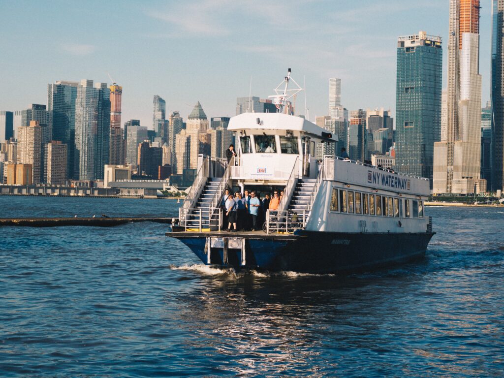 image of a ferry on a the water with a city in the background