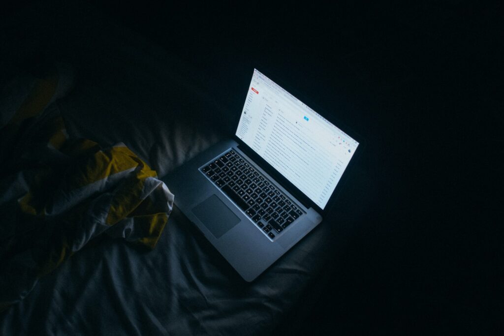 dark room with laptop screen showing email
