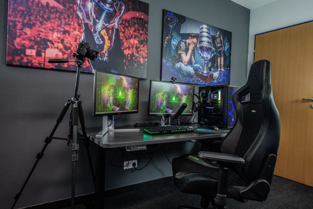 multiple computer screen monitors on a desk with a gaming chair