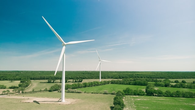 wind turbines with green farmland background and blue skies