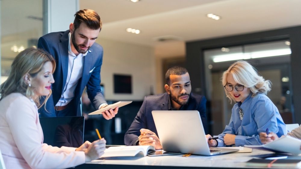 Professionals in an office collaborating happily